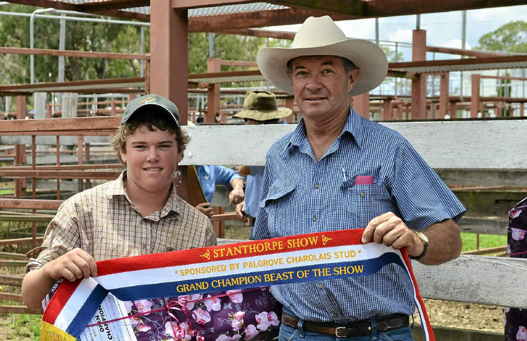 SUCCESS: Ballandean’s Adam Williamson accepts the grand championship broad ribbon from well known Southern Downs cattleman David Bondfield. SUCCESS: Ballandean’s Adam Williamson accepts the grand championship broad ribbon from well known Southern Downs cattleman David Bondfield.